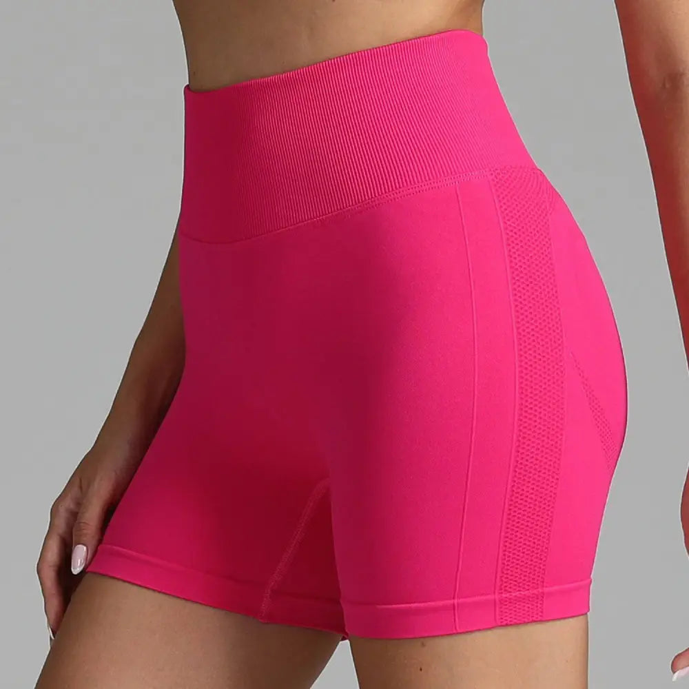 Pink high waist seamless yoga shorts with ribbed waistband and mesh panel for women in bright pink color