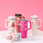 Pink insulated tumbler with white kiss print design steel handle straw ideal for travel and hot or cold beverages