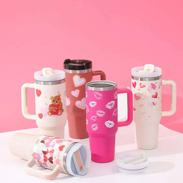 Pink insulated tumbler with white kiss print design steel handle straw ideal for travel and hot or cold beverages