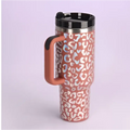 Pink kiss insulated tumbler with pink and white leopard print, stainless steel handle straw, black lid and handle