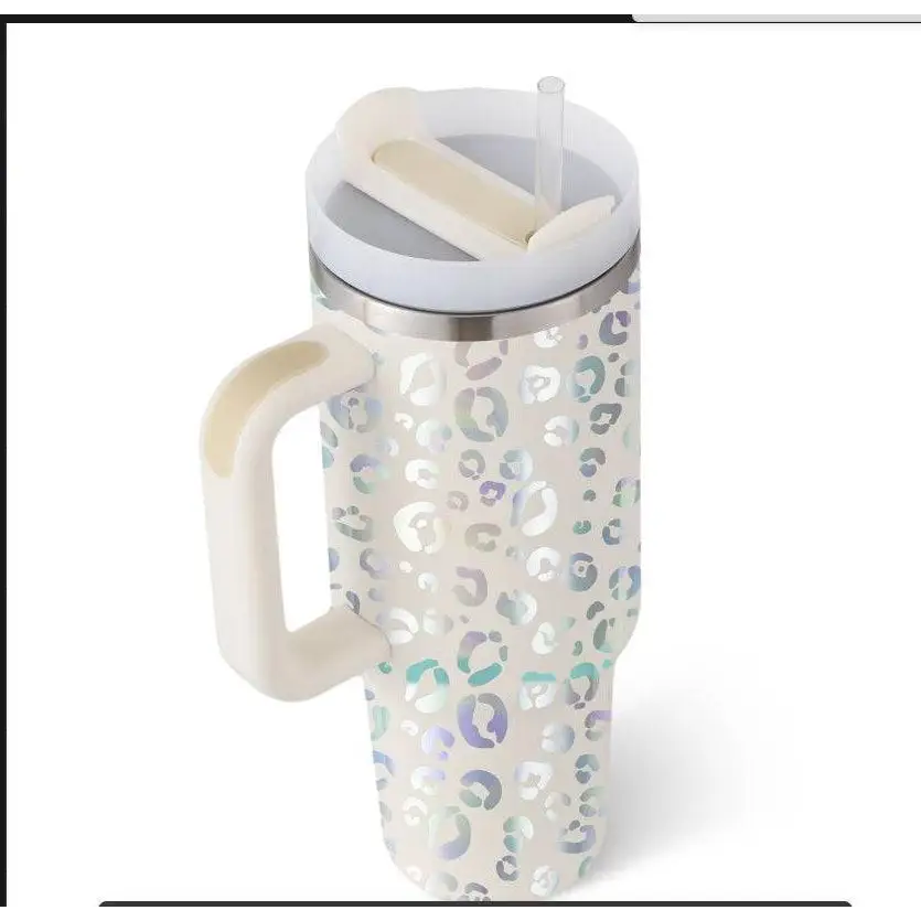 A tall cream-colored pink kiss insulated tumbler with steel handle straw featuring a shimmering leopard print pattern