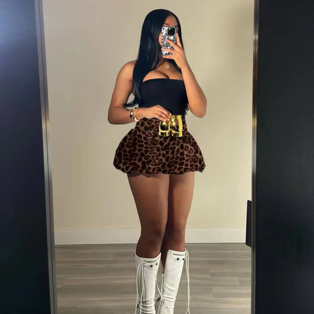 Gold-toned binoculars belt buckle complements pink leopard print pleated skirt with flared hem and polished finish