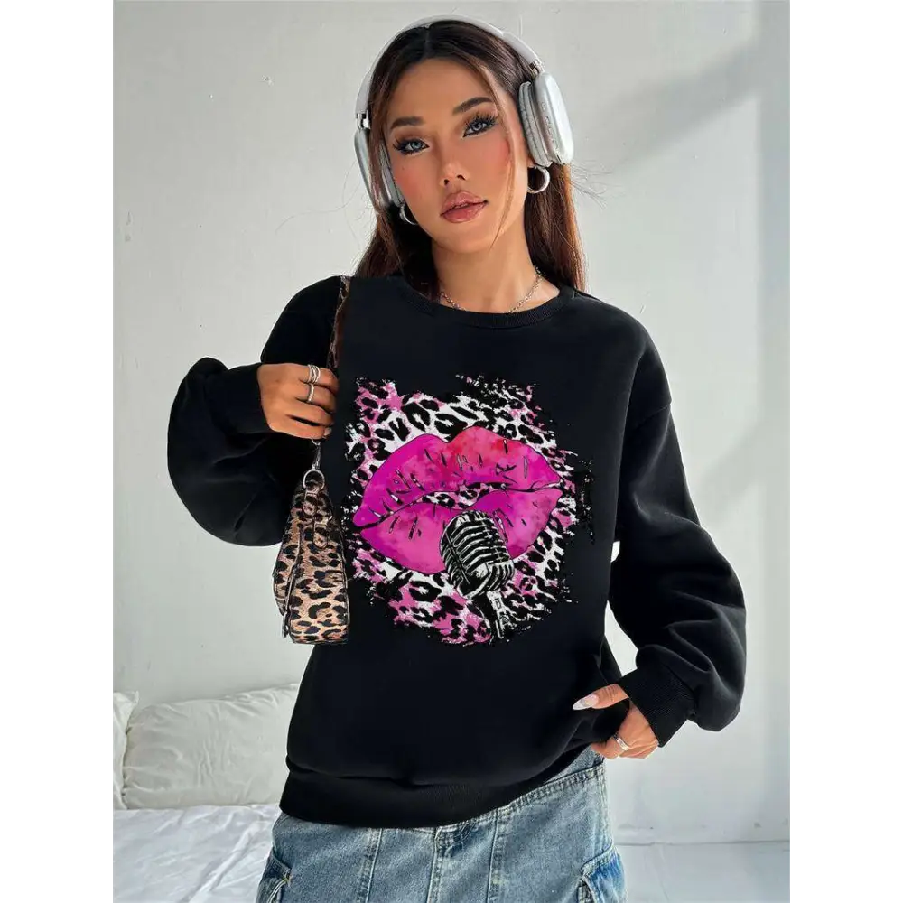 Black oversized crew neck sweatshirt featuring bold pink lips and vintage microphone graphic on leopard print background
