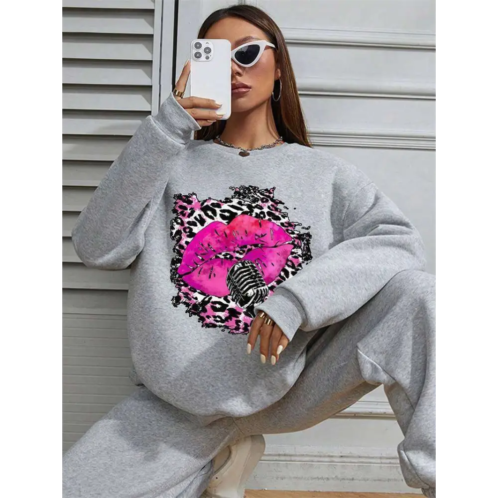 Gray oversized crew neck sweatshirt featuring bold pink lips graphic with leopard print and vintage microphone design