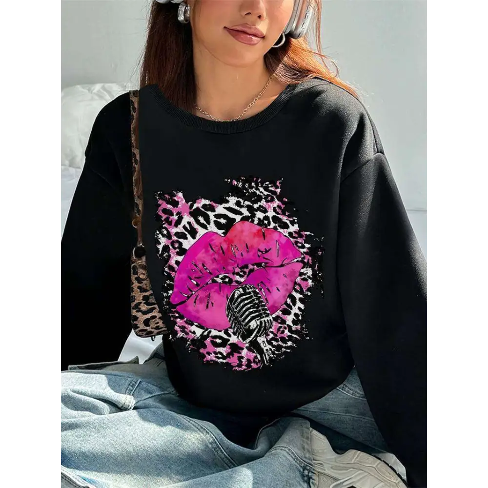 Black oversized crew neck sweatshirt featuring vibrant pink lips with leopard print and vintage microphone design