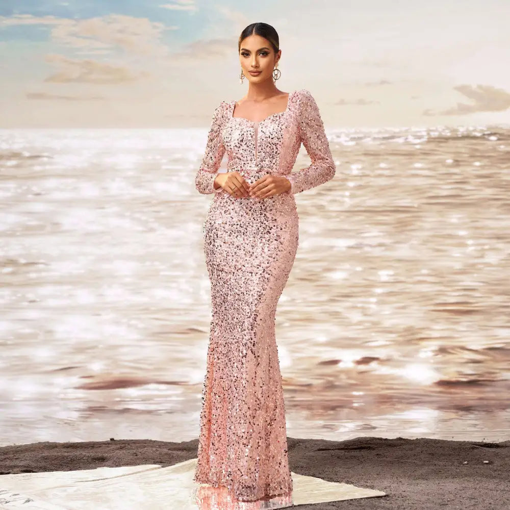 A shimmering pink long sleeve sequined sheath fishtail evening dress with a square neckline and fitted silhouette