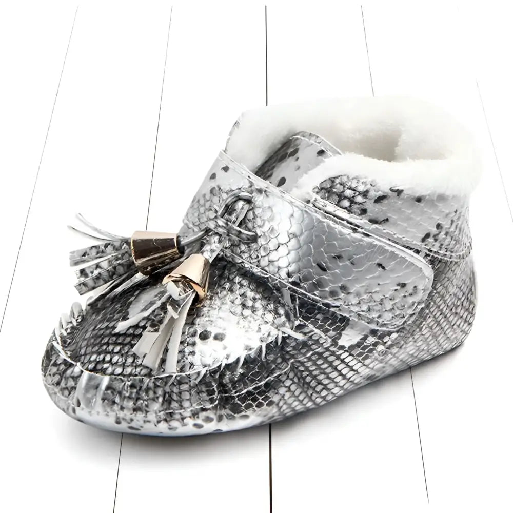 Silver snake-print baby shoes with white faux fur lining and gold-toned tassel in pink metallic toddler shoes style