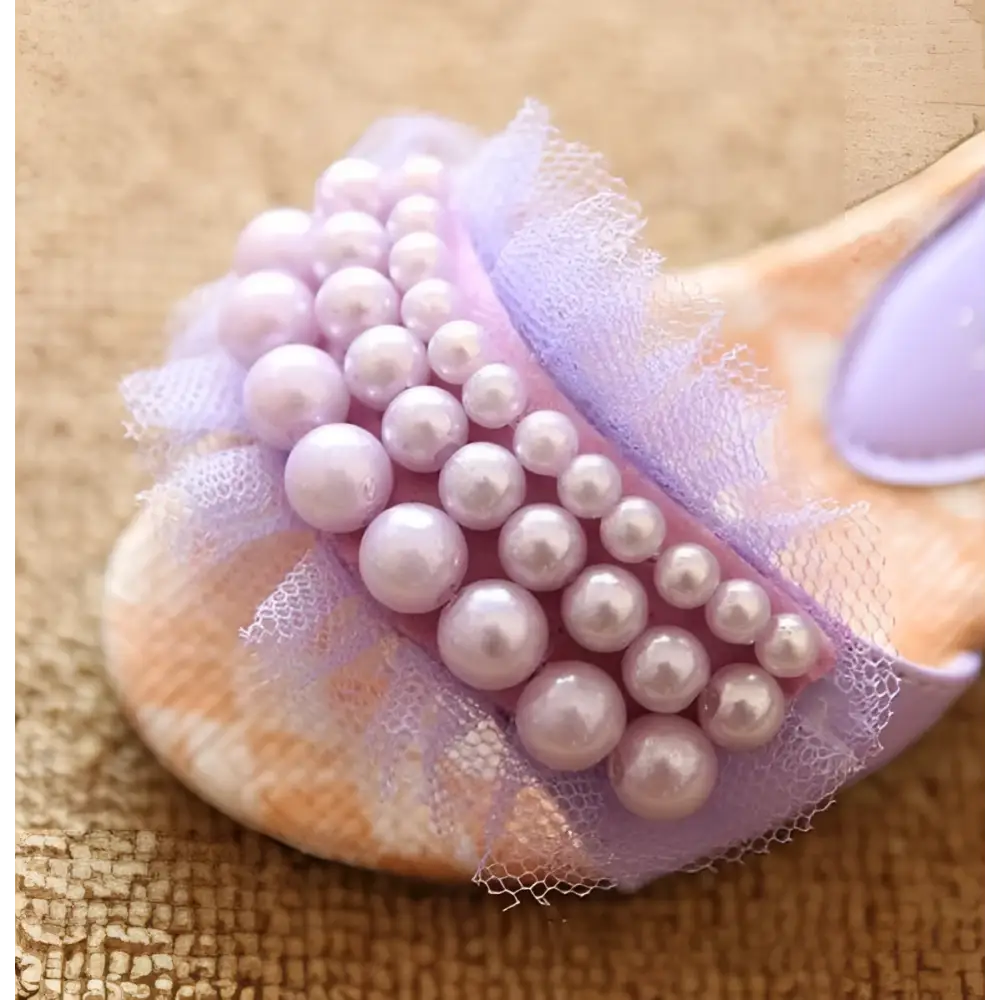 A soft peach slip-on sandal featuring delicate lavender mesh summer girls with pink pearl mesh embellishments