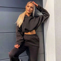 Black cropped hoodie with long sleeves and drawstring hood paired with matching sweatpants in pink piece sweatsuits sexy cropped set