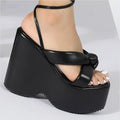 Black platform wedge sandal with thick glossy sole and ankle strap in contrast to pink platform wedge style
