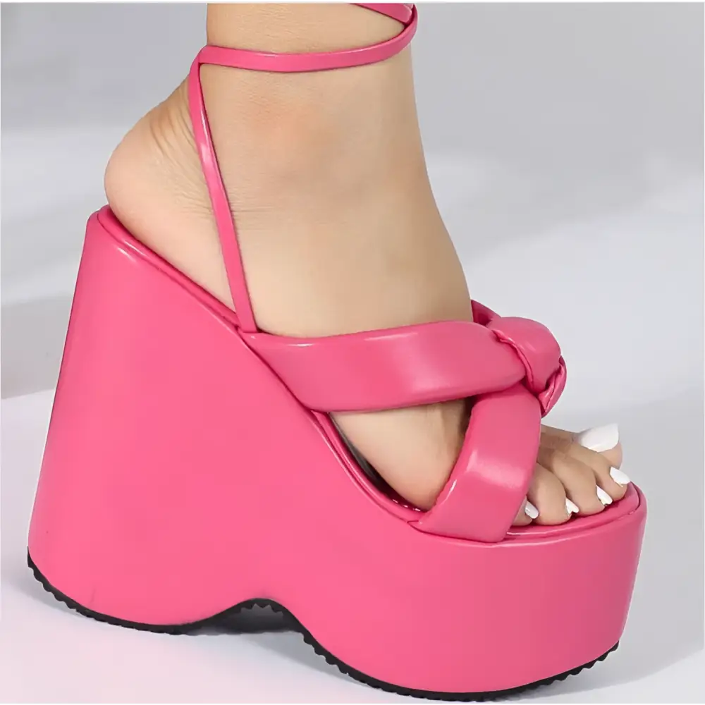 Bright pink platform wedge sandal with glossy finish, crisscross straps, and ankle tie for stylish wear