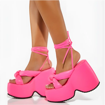 Bright pink platform wedge high heel sandals with thick glossy straps and crisscross ankle tie for stylish wear