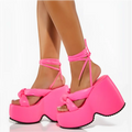 Bright pink platform wedge sandals with thick glossy straps and crisscross ankle tie for stylish wear