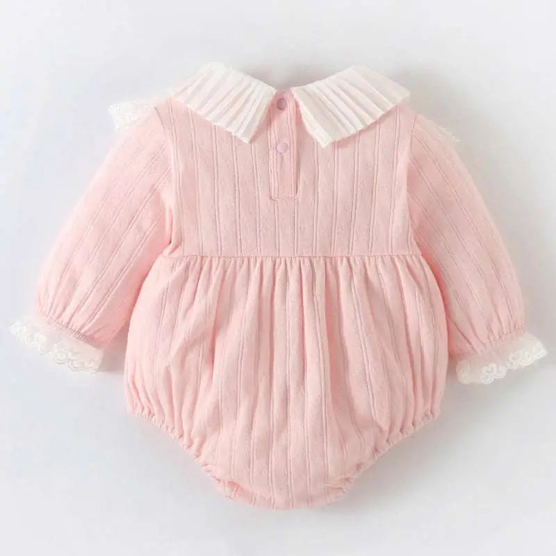 A soft pink ribbed long newborn clothes jumpsuit with white pleated collar and lace trim at the cuffs