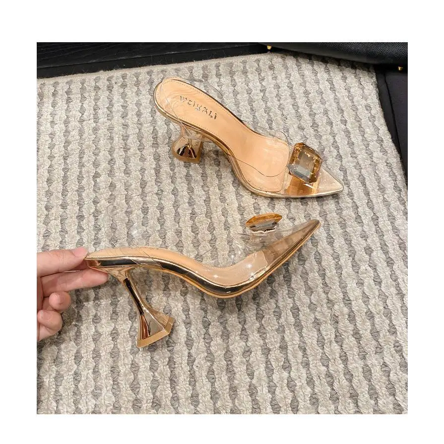 Pink satin bow high-heeled sandal featuring gold-toned transparent mule heels with a geometric crystal accent on the toe