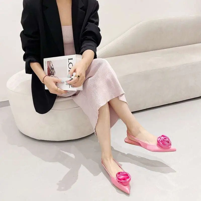 Pink satin floral embellished backless flat sandal featuring three-dimensional rose detail at the toe
