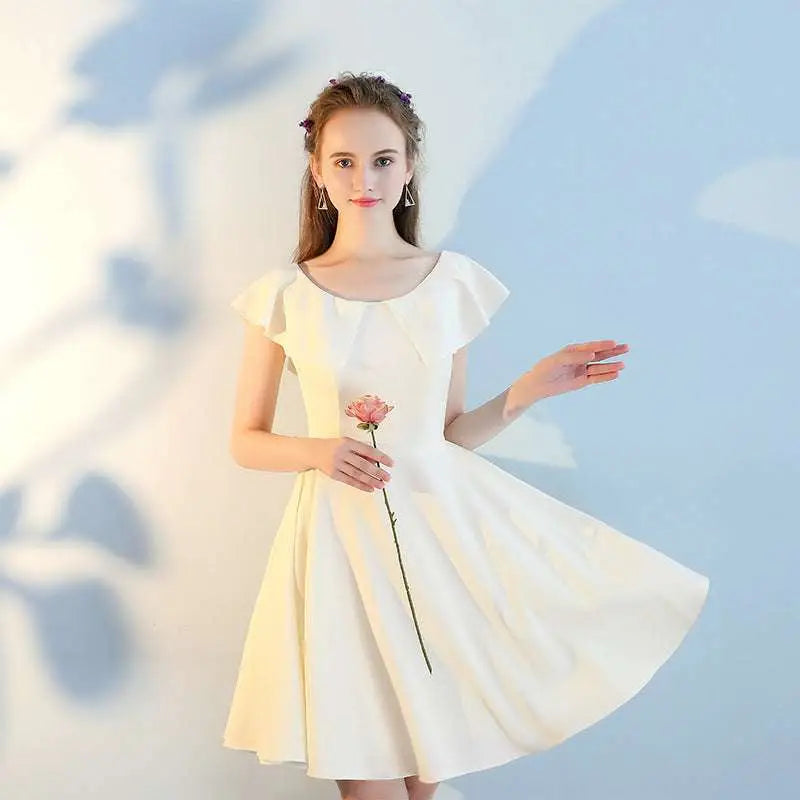A woman wearing a pink short sisters off shoulder shoulder ruffled dress with a flowing off white flared skirt made