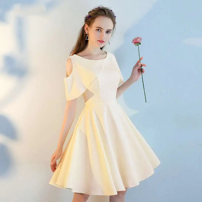 A woman wears an off-white satin pink short sisters shoulder ruffled dress with shoulder cutouts and a flared skirt made