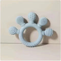 Light blue silicone baby hand teether with textured bristles and ridges for soothing gums in pink silicone baby product line