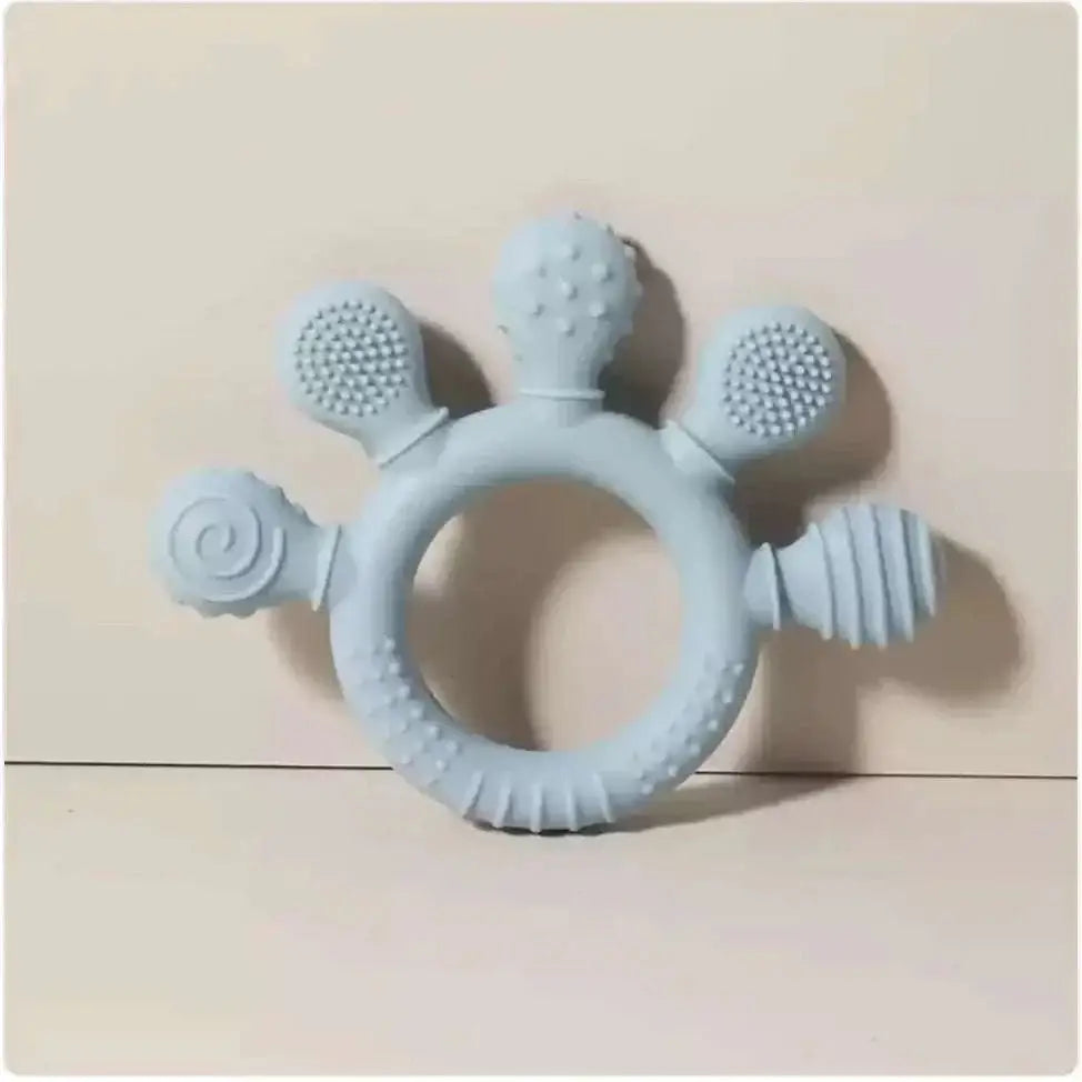 Light blue silicone baby hand teether with textured bristles and ridges for soothing gums in pink silicone baby product line