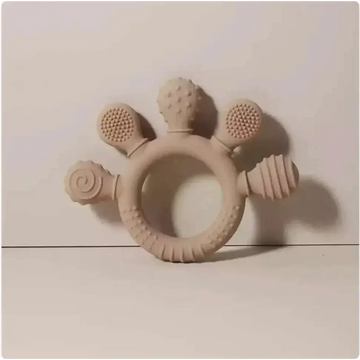 Beige silicone baby hand teether with textured bristles spiral pattern and ridged surfaces for soothing gums