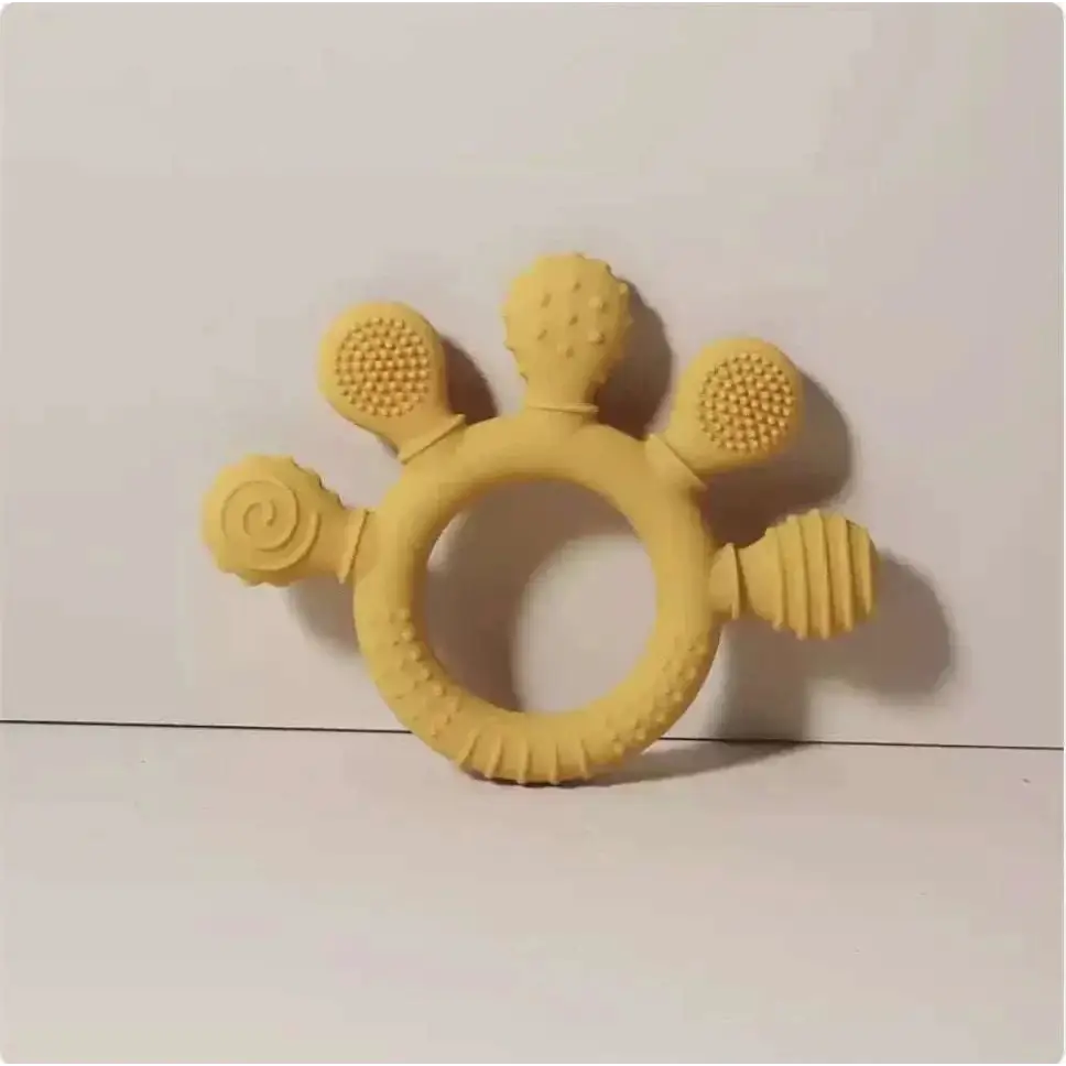 Pink silicone baby hand teether featuring a yellow silicone baby hand ring with spiral, dotted, and honeycomb textures