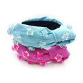 A light blue and pink knotted holiday party headband with translucent star beads in pink star solid design