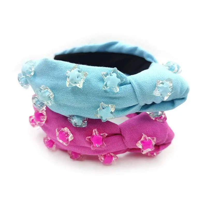 A light blue and pink knotted holiday party headband with translucent star beads in pink star solid design