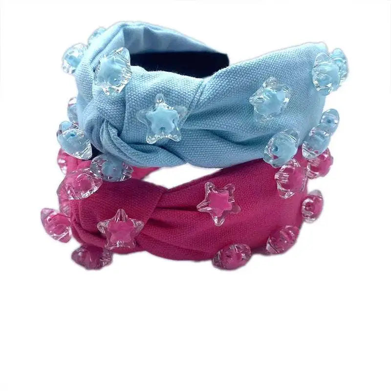 A vibrant pink star solid holiday party headband with knotted design and clear star and rose embellishments