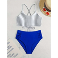 A stylish pink striped bikini split with a white top featuring black vertical stripes and royal blue high-waisted bottoms