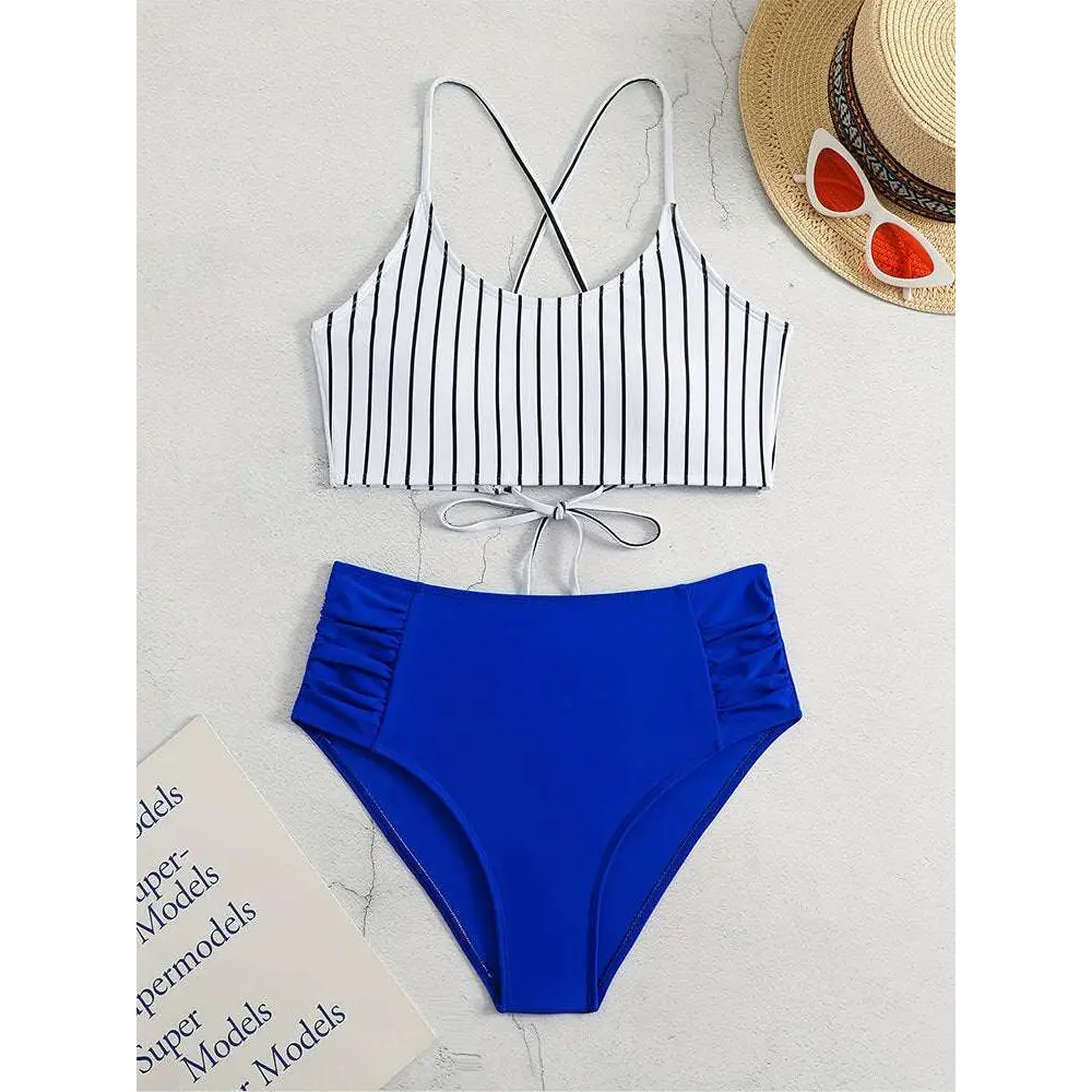 A stylish pink striped bikini split with a white top featuring black vertical stripes and royal blue high-waisted bottoms