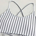 White bikini top with black vertical stripes and thin crossed shoulder straps from pink striped bikini split swimsuit for women