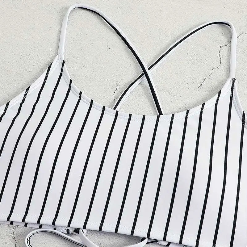 White bikini top with black vertical stripes and thin crossed shoulder straps from pink striped bikini split swimsuit for women
