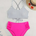 Pink high-waisted bikini bottom with ruched side panels featuring black vertical stripes in a striped bikini split design
