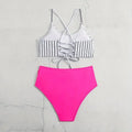 A pink high-waisted bikini bottom paired with a white and black vertical striped bikini split top with lace-up detailing