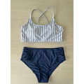 White and navy blue striped bikini crop top with crossed shoulder straps complementing a pink striped bikini split design