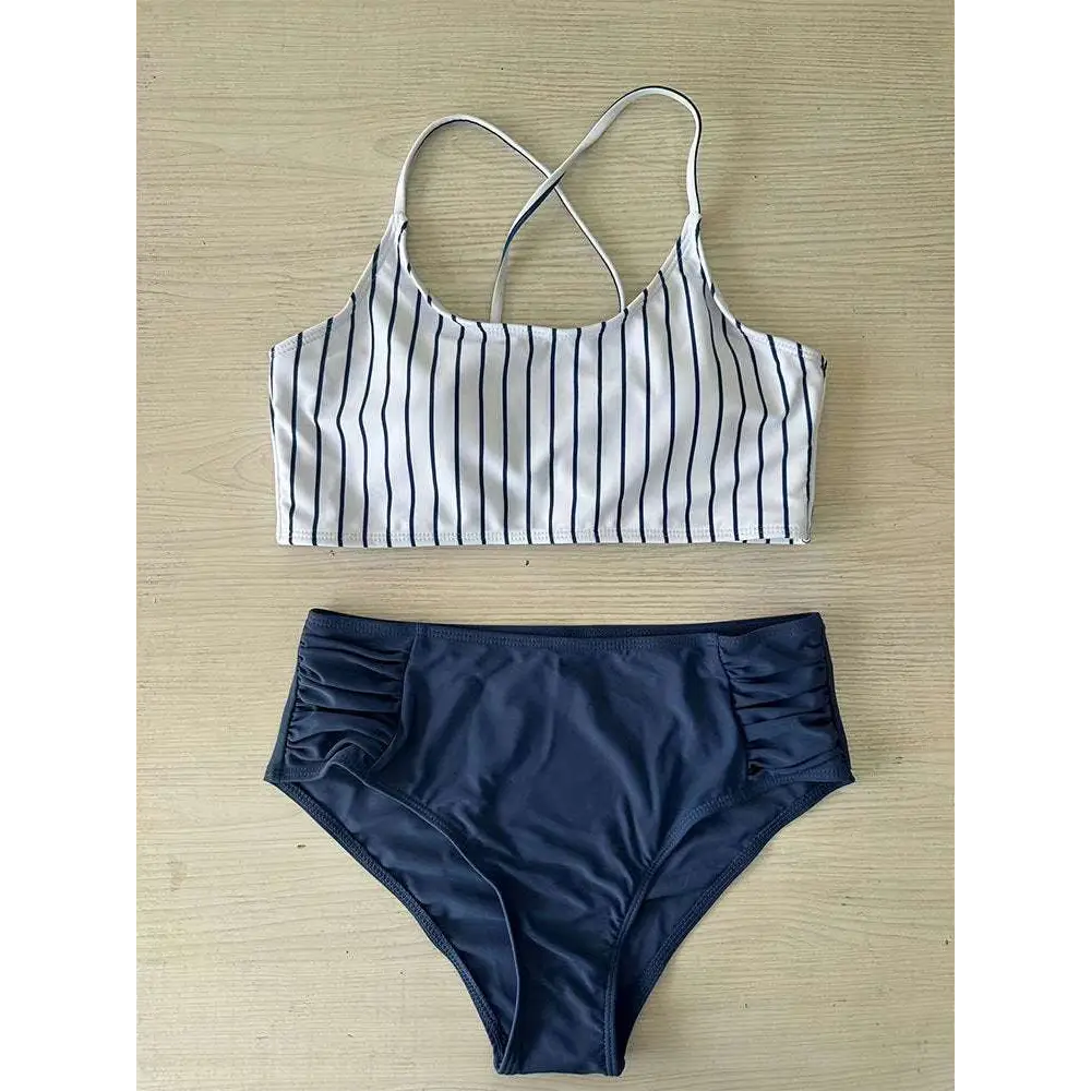 White and navy blue striped bikini crop top with crossed shoulder straps complementing a pink striped bikini split design
