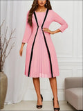 Pink striped pleated midi dress in luxury women’s fashion featuring black vertical stripes and a flowing pleated skirt