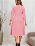 A soft pink striped pleated midi dress with three-quarter sleeves and a flared skirt for luxury women’s fashion
