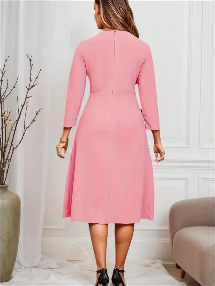 A soft pink striped pleated midi dress with three-quarter sleeves and a flared skirt for luxury women’s fashion
