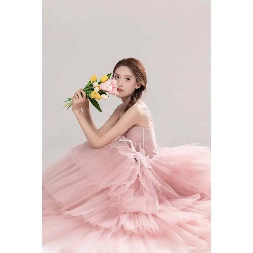 A soft pink tulle wedding photography dress with a fitted bodice and voluminous skirt perfect for dress pink white themes