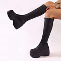 Black platform knee high elastic leather boots with sleek stretchy upper and thick chunky sole for stylish wear