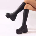 Black elastic leather platform knee high boots with sleek stretchy material and bold wedge soles