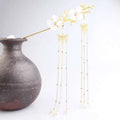 A delicate gold-toned plum blossom ancient style hairpin with white floral beads and pearl-adorned chains for hanfu