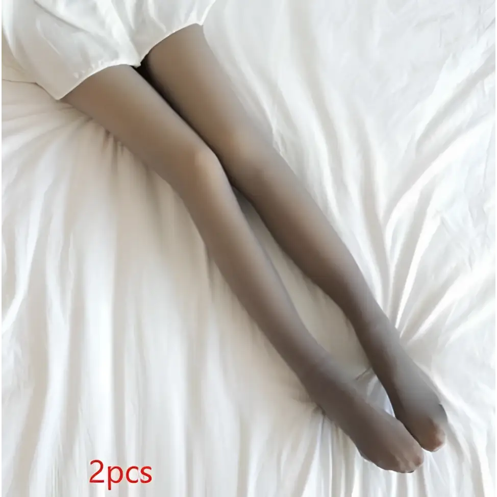 A pair of plus size fleece lined tights in sheer skin tone worn over white shorts showing fake translucent fleece texture