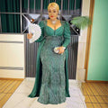 Plus size long sleeve sequined evening dress in emerald green with intricate silver beading and flowing capelet