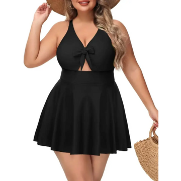 Black plus size tummy control bathing suit with halter neckline, front bow, and flared skirt one-piece design