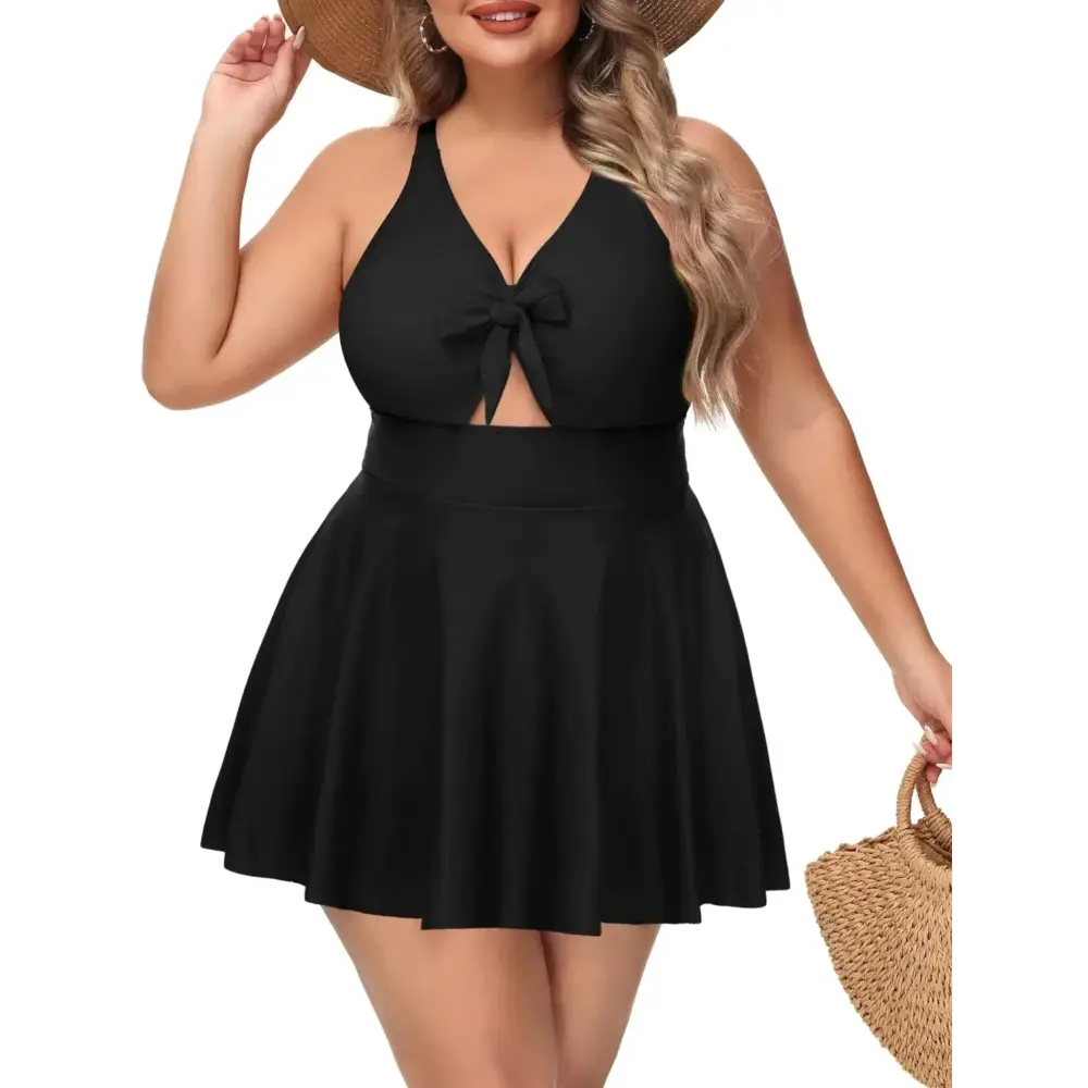 Black plus size tummy control bathing suit with halter neckline, front bow, and flared skirt one-piece design