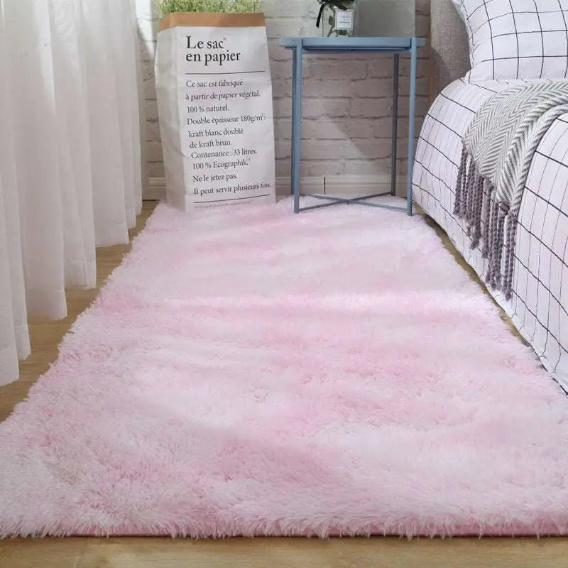 A plush gray shaggy carpet floor mat with soft fluffy texture and slightly frayed edges in gradient pink tones