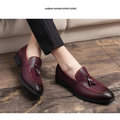 Pointed men’s slip woven leather shoes in burgundy with decorative tassels and black rubber soles